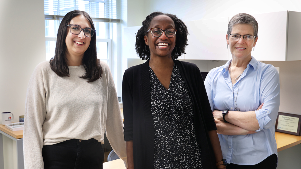 Three women standing in office.