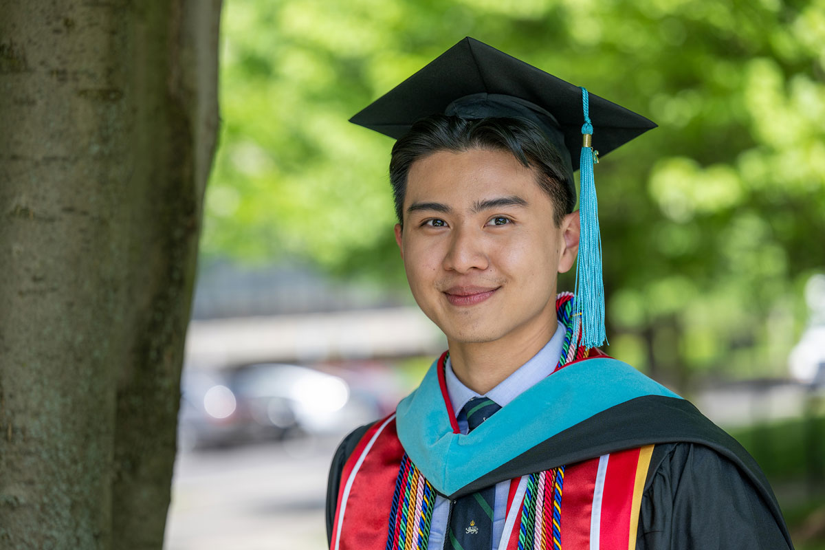 Sloan student Jacky in cap in gown during graduation