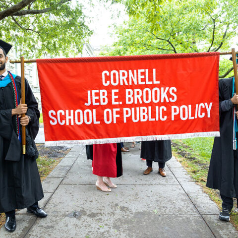 Two Brooks students holding Brooks School graduation banner