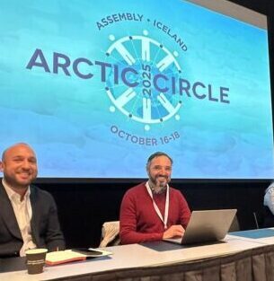4 people sitting at conference table presenting