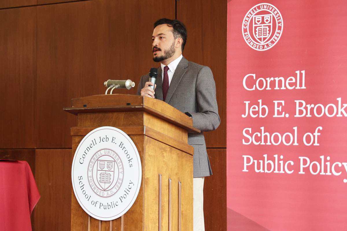 MPA student standing at podium with red Brooks School banner behind them
