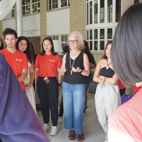 Students meet with Professor Carmalt in brightly lit atrium
