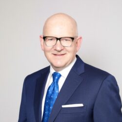 man in blue suit and tie smiling