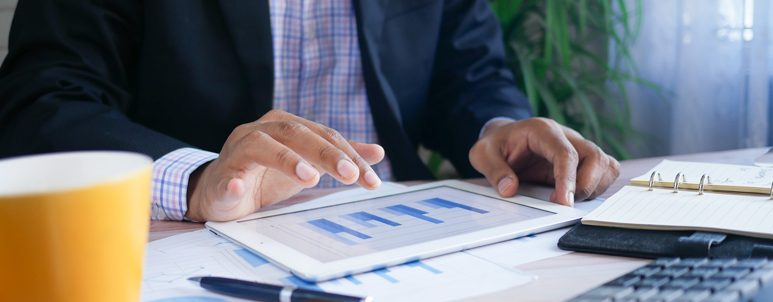 Man looking at charts on tablet