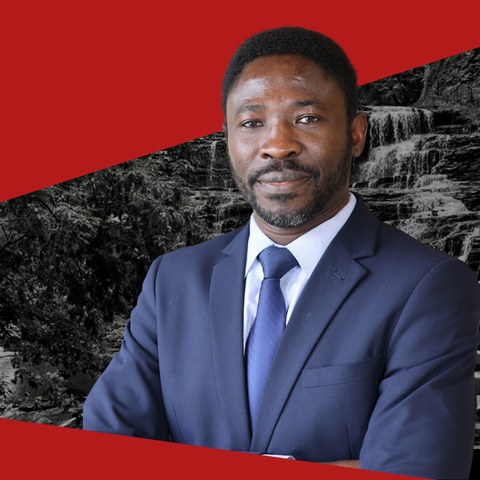 Cornell student in blue suit with waterfall behind him