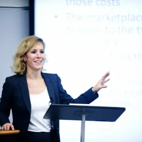 Sarah Kreps standing at podium presenting in front of a screen