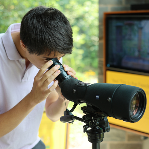 Student looking through telescope at the Cornell Lab of Ornithology