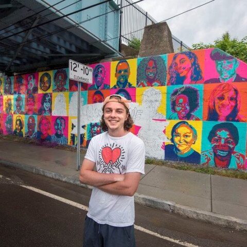 Student standing in front of murals