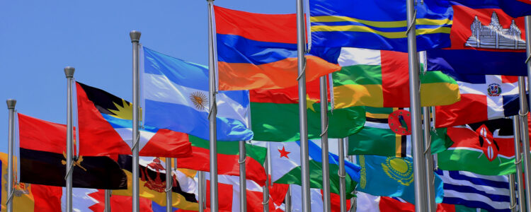 Row of 20 international flags in blue sky