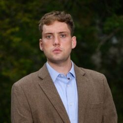 PhD student Ryan Dycus against dark background