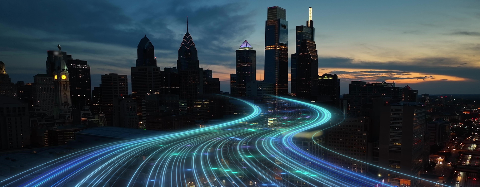 City skyline at night with blurred bright blue lines showing movement