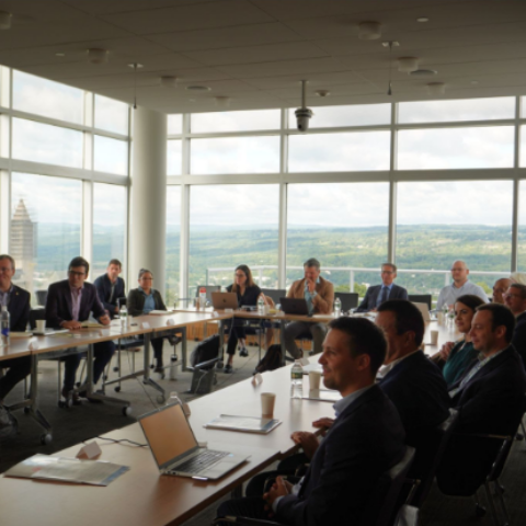 A group of people sit around a conference table.