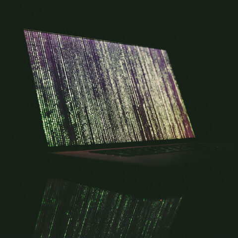 Screen with multiple lines of computer code in front of dark background
