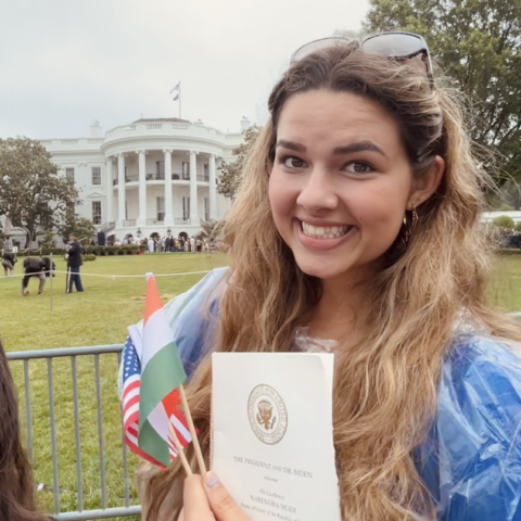 Undergraduate student standing outside of the white house smiling