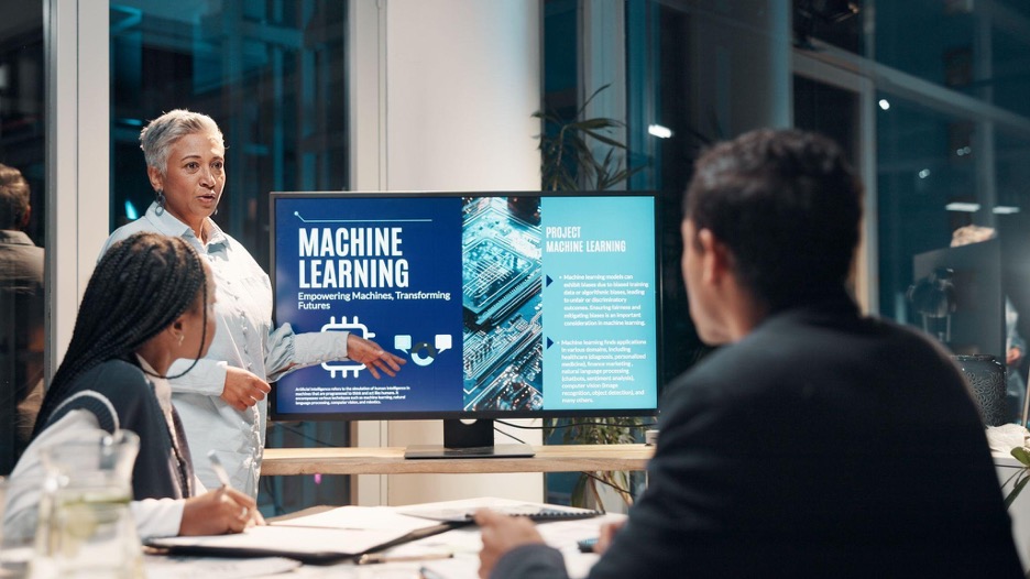 Group of people in a conference room discussing a presentation on AI