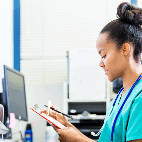 Nurse working on a clipboard at a head nurse station