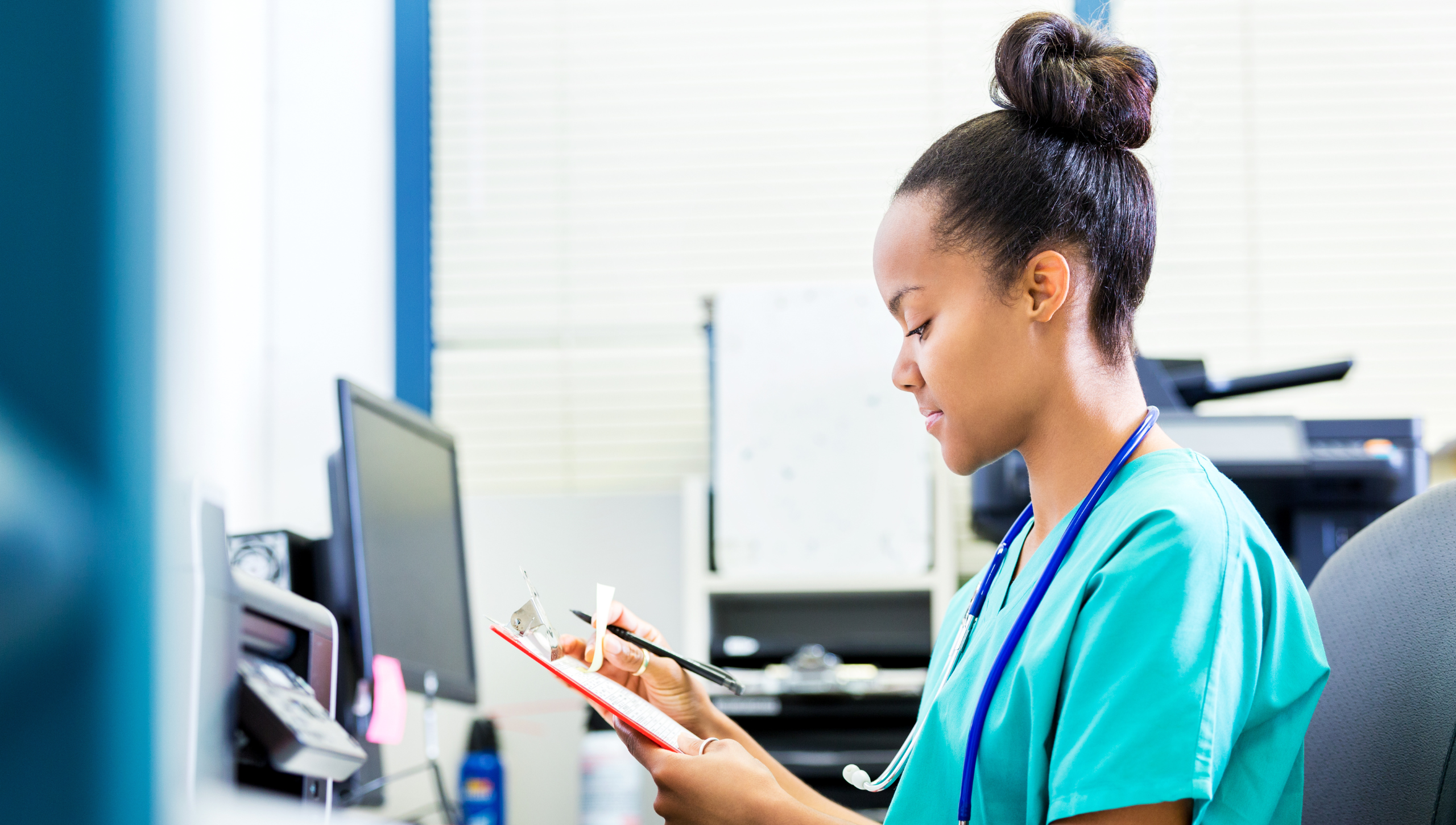 Nurse working on a clipboard at a head nurse station