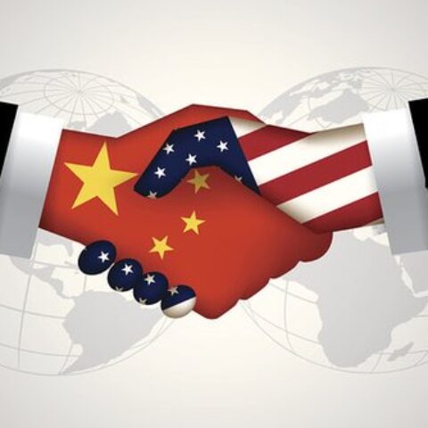 two hands shaking, one filled in with the American flag, the other filled in with the China flag